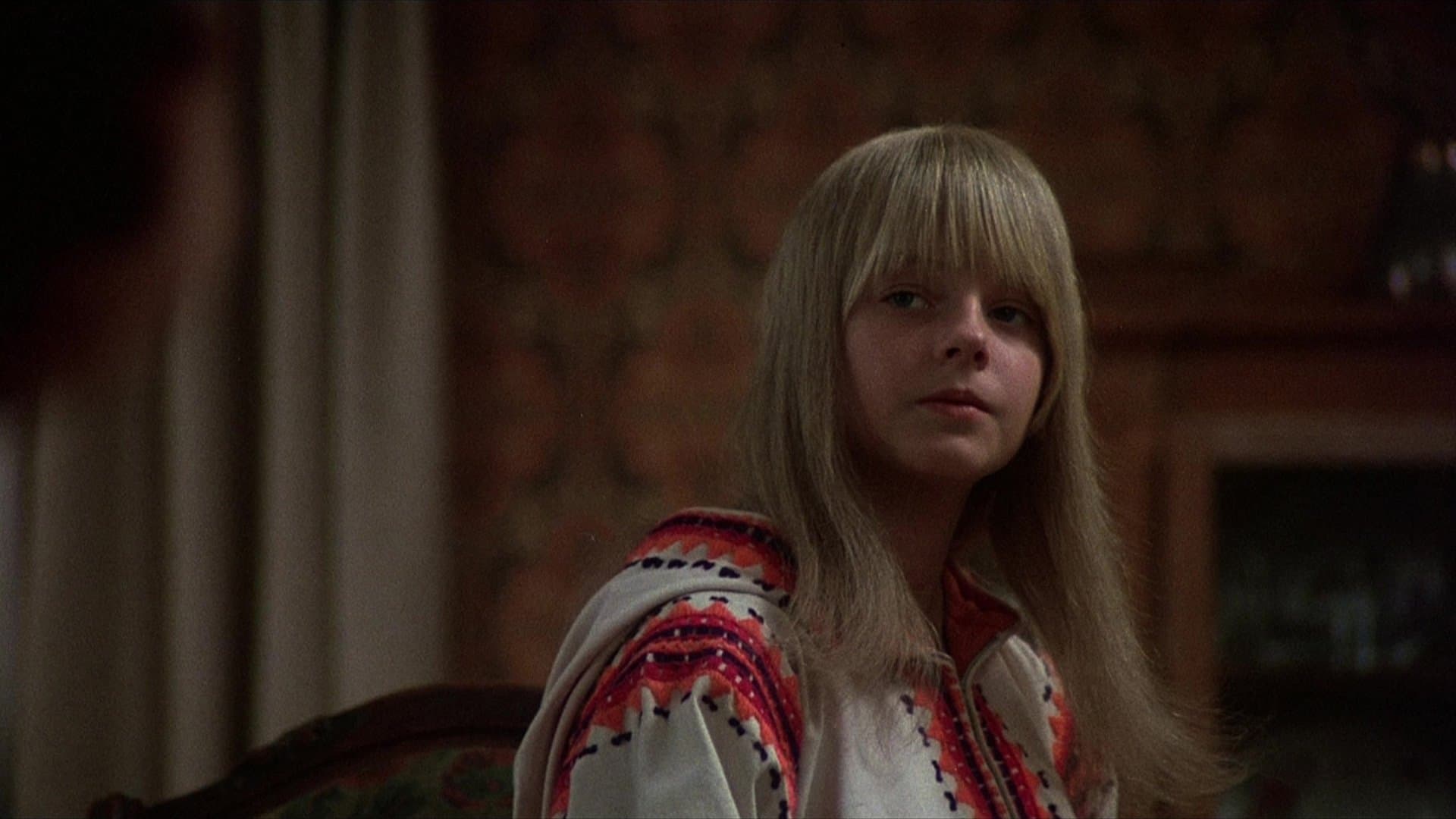 Fetița care stă mai jos pe stradă